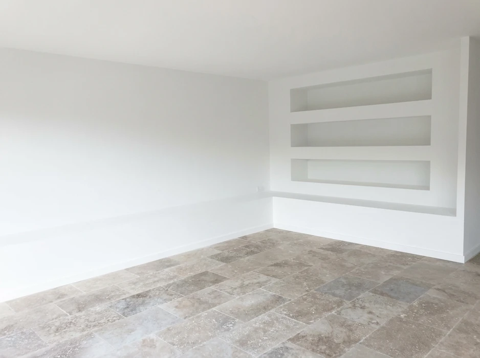Pièce vide aux murs blancs avec niches encastrées intégrées, composées de trois étagères horizontales en plaques de plâtre peintes