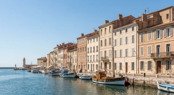 Photographie de la ville de S&egrave;te prise depuis le port ou la mer, montrant les fa&ccedil;ades color&eacute;es des immeubles r&eacute;sidentiels typiques de la cit&eacute; c&ocirc;ti&egrave;re, avec les b&acirc;timents et l'architecture locale repr&eacute;sentative du tissu urbain o&ugrave; intervient l'entreprise de pl&acirc;trerie et r&eacute;novation. L'image doit capturer l'identit&eacute; visuelle distinctive de S&egrave;te sans texte, logo ou filigrane visible.