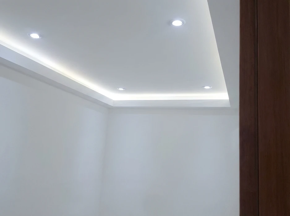 Plafond à caisson en plâtre blanc avec éclairage indirect LED intégré dans une corniche en retrait