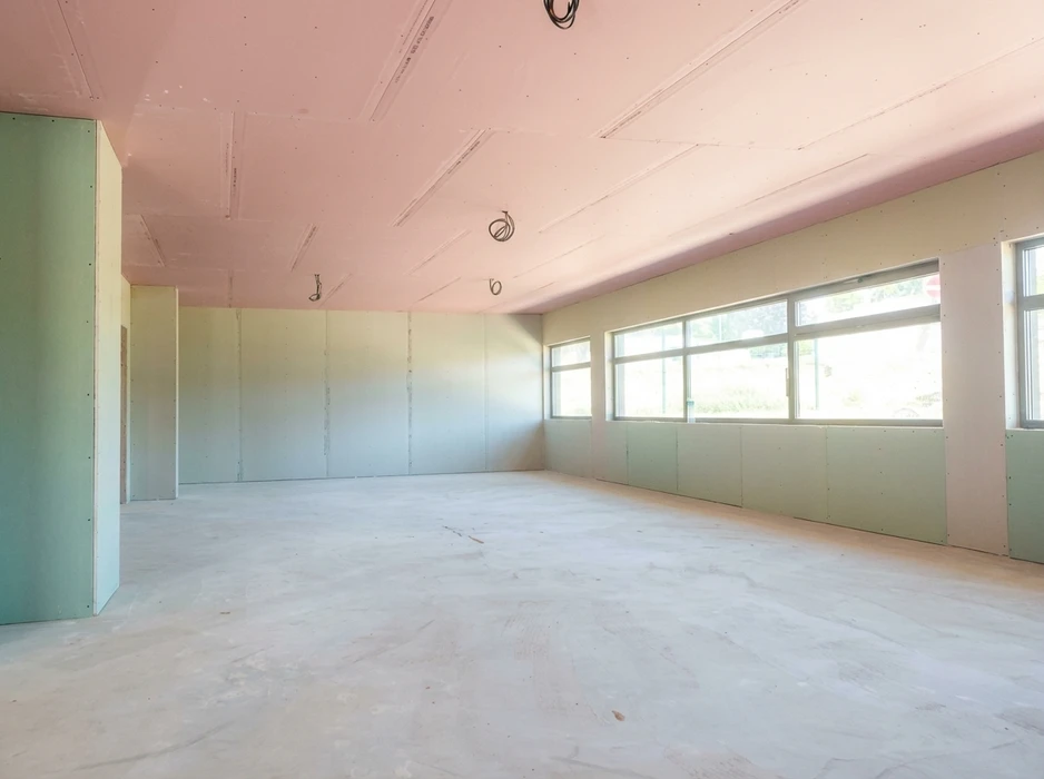 Chantier intérieur en cours, pièce vide avec sol en béton brut