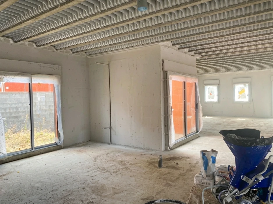 Intérieur d'un bâtiment en cours de construction, vue depuis un espace ouvert non fini